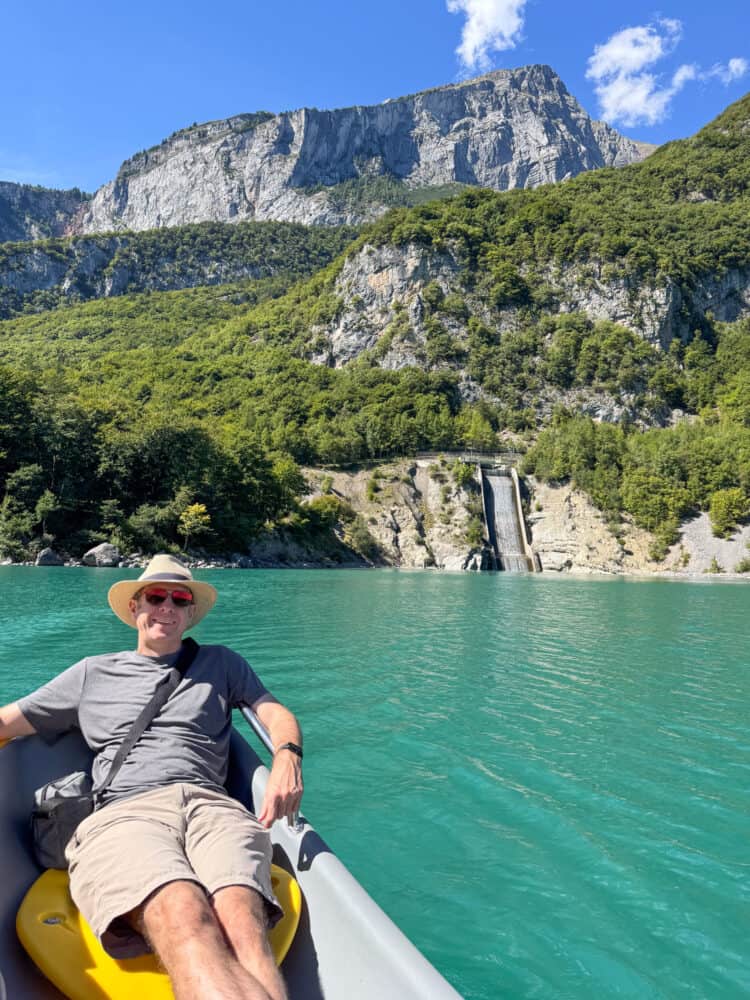 Simon on a Gogo boat in Lake Molveno with the hydropower waterfall behind