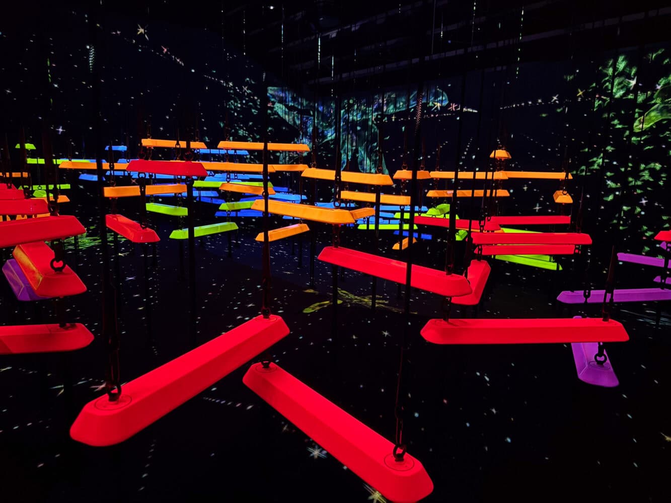 Aerial Climbing through a Flock of Colored Birds at TeamLab Biovortex Kyoto.