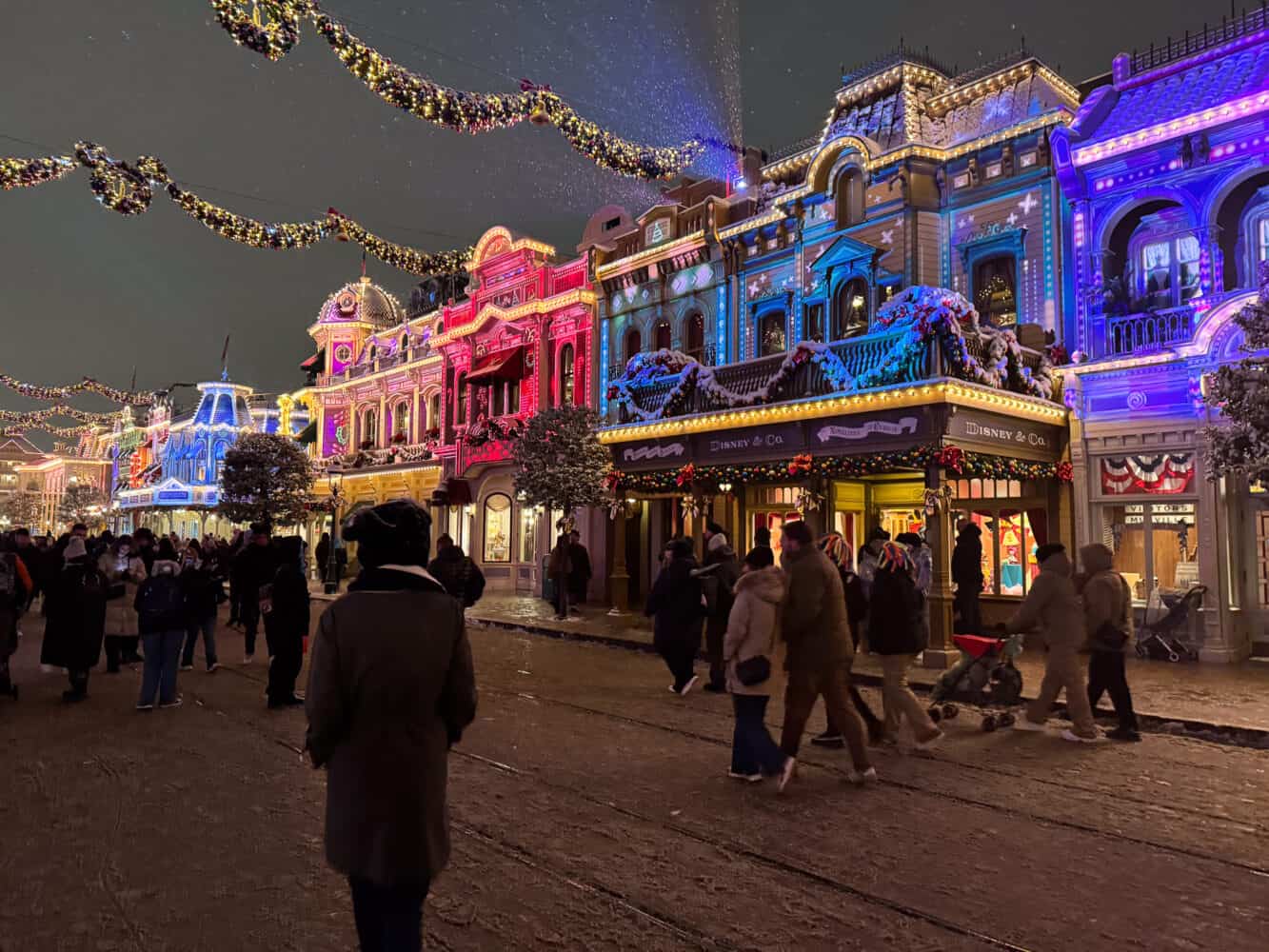 Main Street USA at Disneyland Paris at Christmas with colourful projections on the buildings.